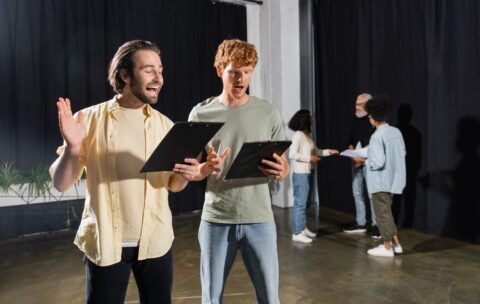 Redhead,And,Brunette,Students,Holding,Scenarios,And,Rehearsing,In,Acting
